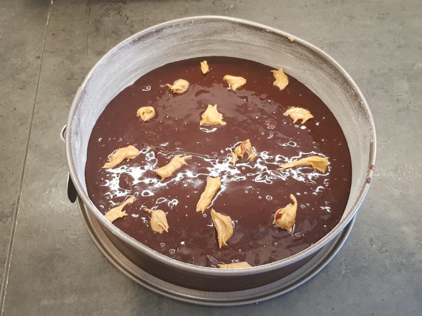 Pâte avec les morceaux de beurre de cacahuète dans un moule à gateau 