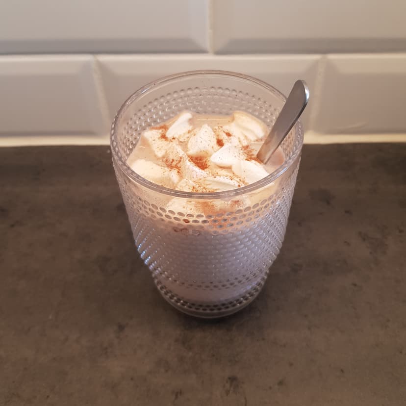 Chocolat chaud à la cannelle dans un verre avec des guimauves 