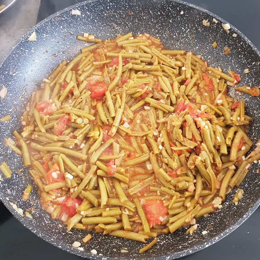 Haricots en train de mijoter avec les tomates et l'assaisonnement 