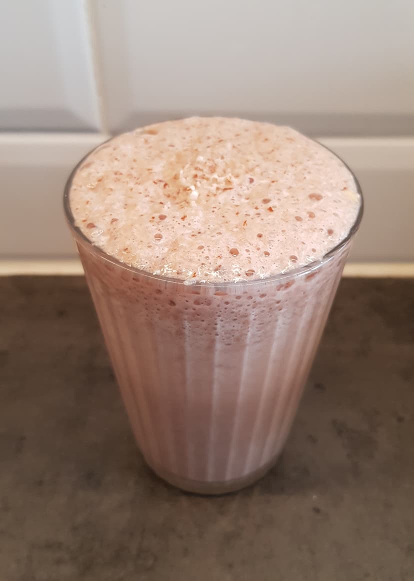 Milkshake chocolat versé dans un verre avec une paille en inox 